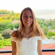 A student standing with trees in the background