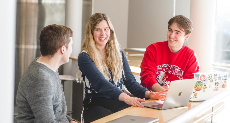 three students at a laptop