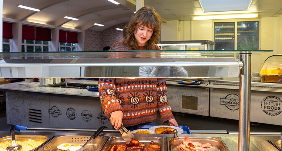 A student serving food to themself in the Lopes Hall Dining Room